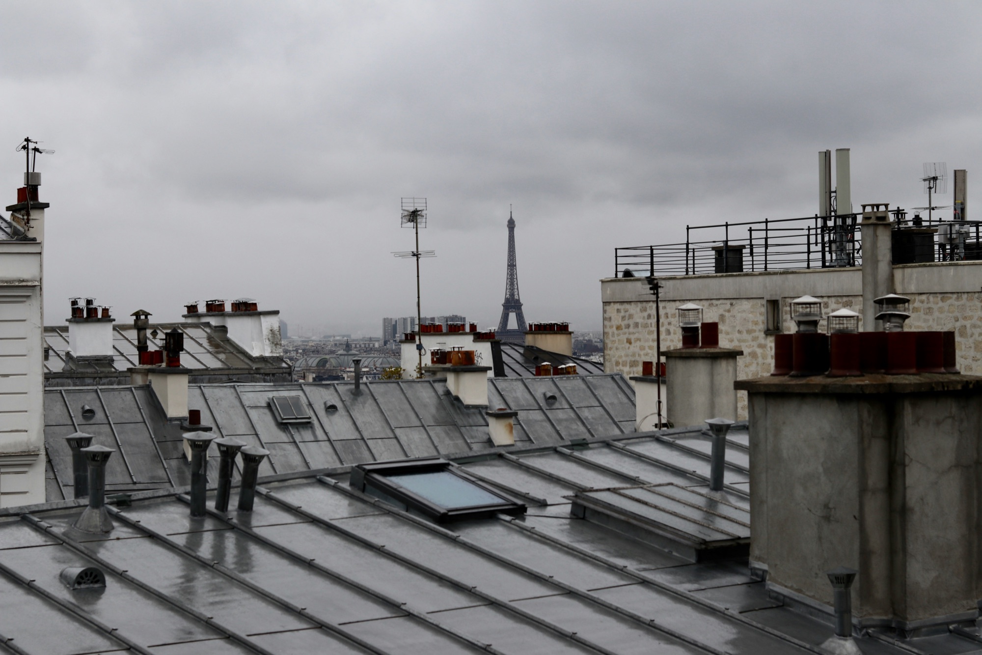 Toits en zinc d’immeubles parisiens, avec leurs cheminées et des fenêtres de toit